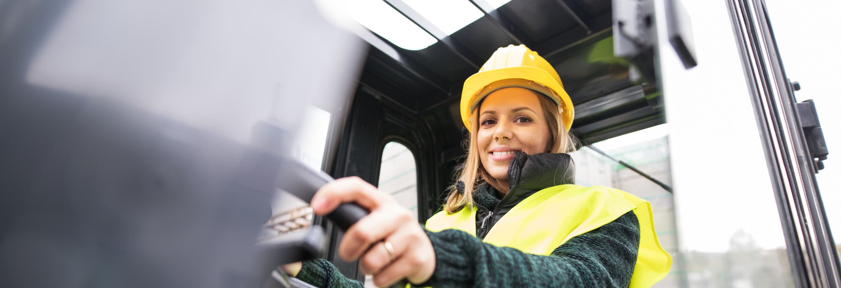 Smilende kvinne som kjører lastebil, og representerer selvtillit, profesjonalitet og mangfold i transportbransjen