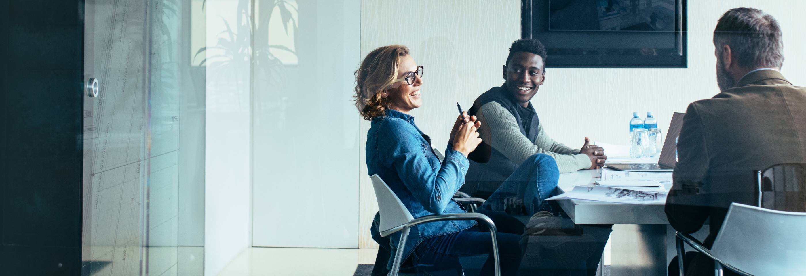 Smilende ansatte fra rekrutteringsbyrå i kundemøte