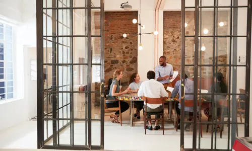 Kolleger som diskuterer i et møterom, deler ideer og fremmer samarbeid